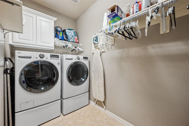 laundry room featuring washer and dryer, cabinet space, baseboards, and light tile patterned floors