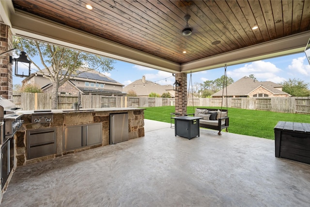 view of patio / terrace featuring grilling area, area for grilling, an outdoor hangout area, a sink, and a fenced backyard