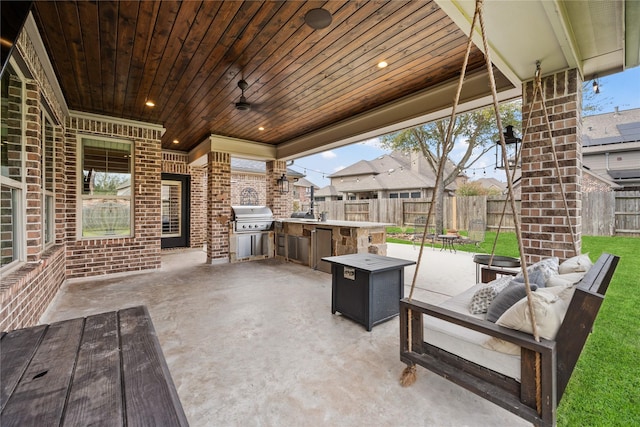 view of patio with an outdoor living space with a fire pit, exterior kitchen, area for grilling, and fence