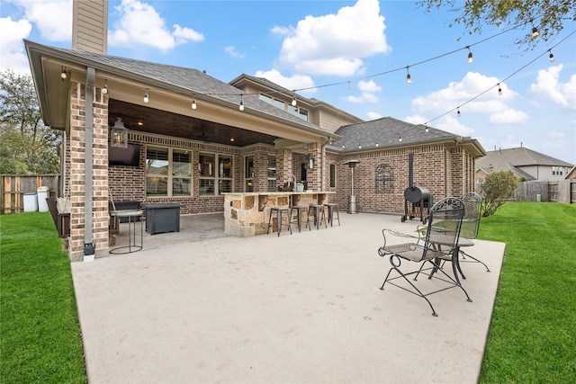 view of patio / terrace with a ceiling fan, fence, and outdoor dry bar