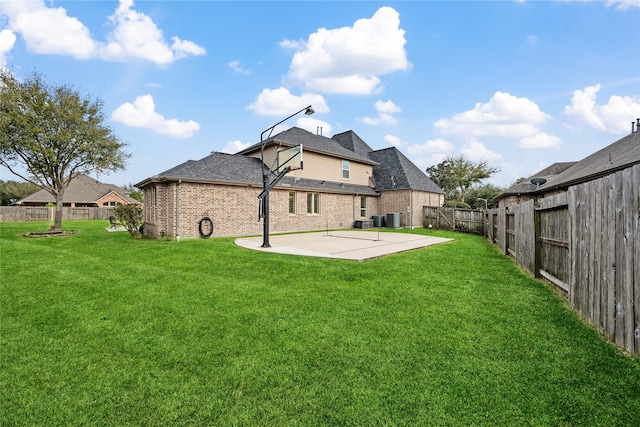 back of property featuring a lawn, a patio, a fenced backyard, central air condition unit, and brick siding