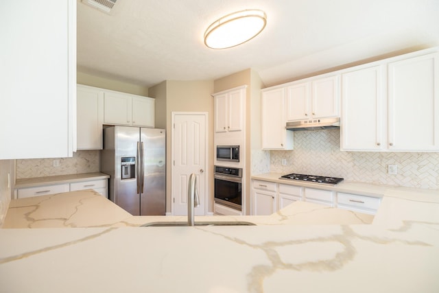 kitchen featuring stainless steel appliances, visible vents, white cabinetry, a sink, and under cabinet range hood