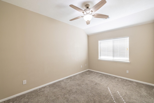 empty room featuring carpet floors, vaulted ceiling, baseboards, and a ceiling fan