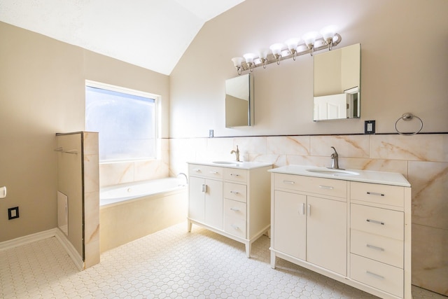 full bathroom with vaulted ceiling, two vanities, a sink, and a garden tub