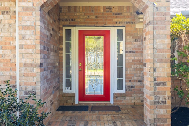 doorway to property with brick siding