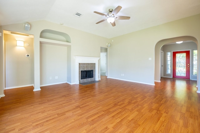 unfurnished living room featuring light wood-style flooring, visible vents, ceiling fan, and a tiled fireplace