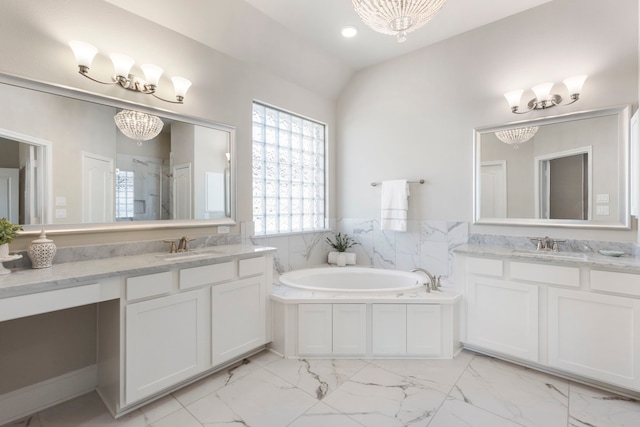 bathroom featuring a garden tub, marble finish floor, a chandelier, and a sink