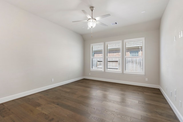 spare room featuring baseboards, dark wood-style floors, visible vents, and ceiling fan