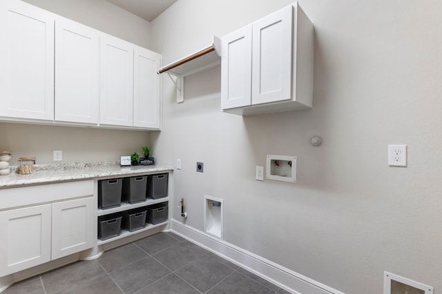 laundry room with washer hookup, hookup for a gas dryer, cabinet space, hookup for an electric dryer, and dark tile patterned flooring