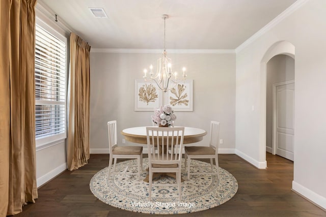 dining room featuring dark wood finished floors, arched walkways, visible vents, and baseboards