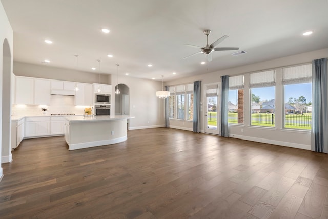 kitchen with open floor plan, arched walkways, visible vents, and stainless steel appliances