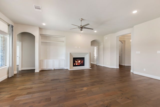 unfurnished living room with recessed lighting, a ceiling fan, a glass covered fireplace, and dark wood-style flooring