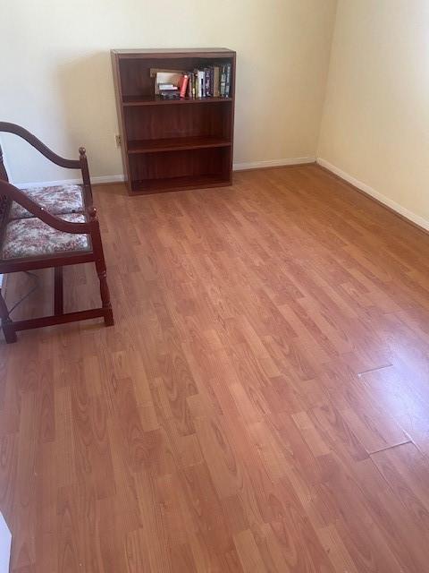 unfurnished room with light wood-type flooring and baseboards