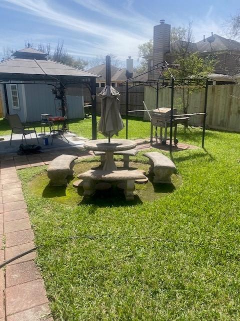 view of property's community with a gazebo, a yard, a patio, and fence