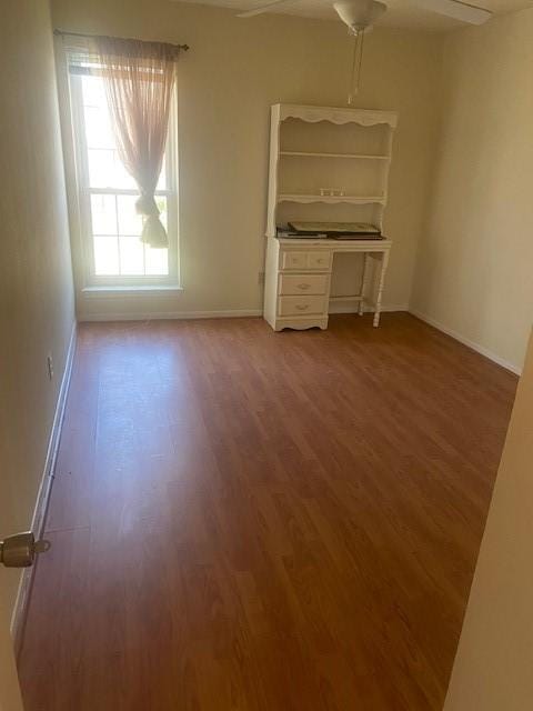 unfurnished bedroom with wood finished floors and baseboards