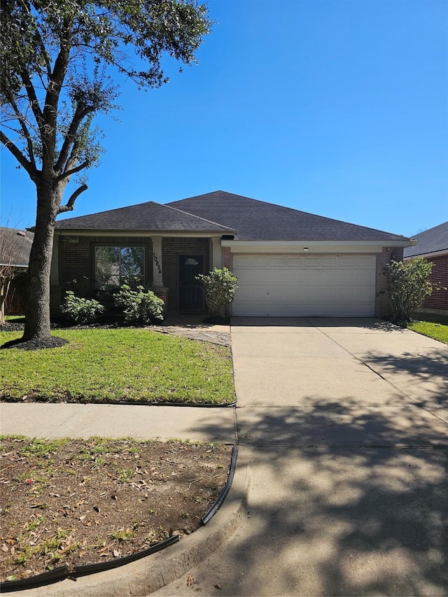 ranch-style home with a garage, driveway, and a front lawn