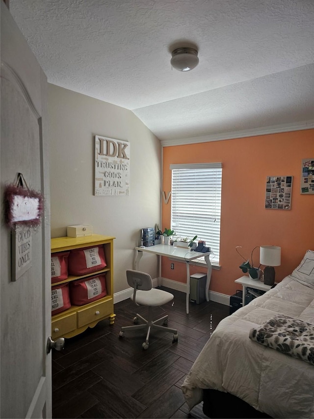 bedroom featuring vaulted ceiling, a textured ceiling, baseboards, and wood finished floors