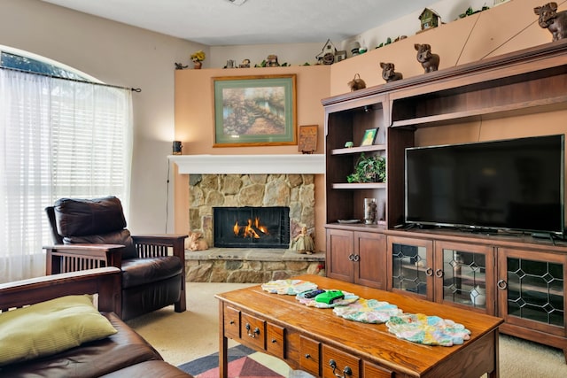 living room featuring light carpet and a stone fireplace