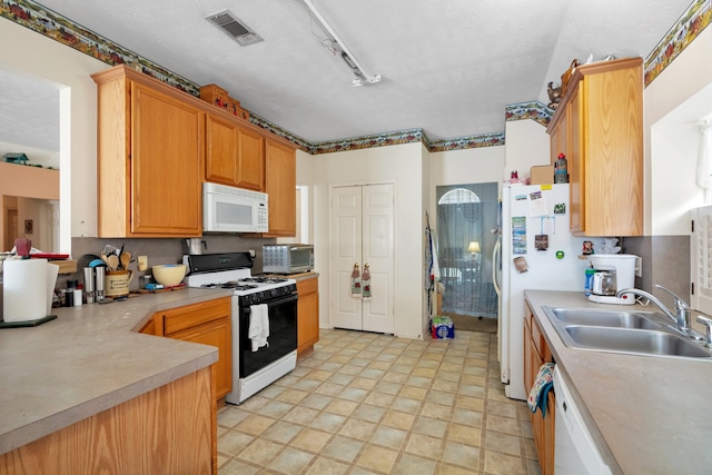 kitchen featuring light countertops, visible vents, a sink, a textured ceiling, and white appliances