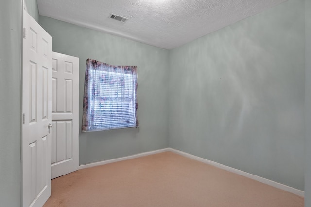 unfurnished room featuring baseboards, visible vents, a textured ceiling, and carpet flooring