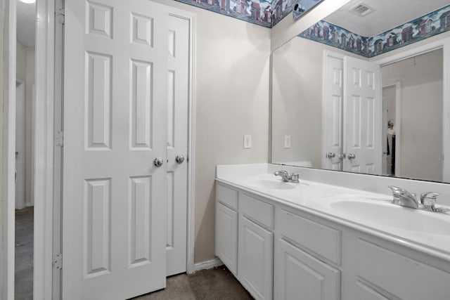 bathroom with double vanity, a sink, and visible vents