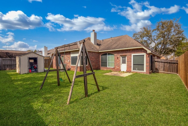 rear view of property with a fenced backyard, a storage unit, an outbuilding, and brick siding