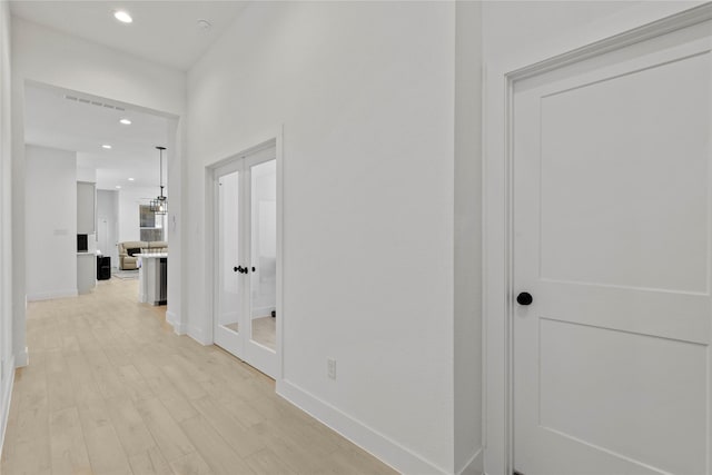 hall with light wood-type flooring, recessed lighting, baseboards, and french doors