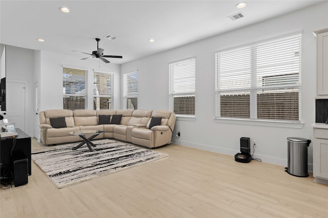 living room with light wood finished floors, visible vents, and recessed lighting