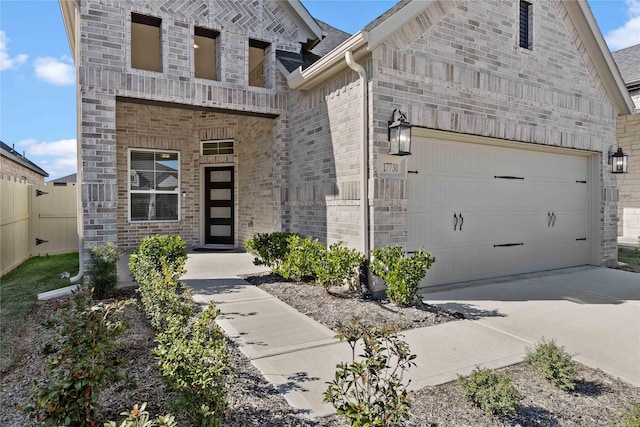 view of front of house featuring a garage, driveway, brick siding, and fence