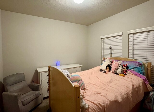 bedroom with carpet and a textured ceiling