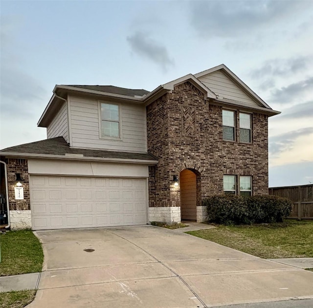 view of front of property with brick siding, a front lawn, fence, a garage, and driveway