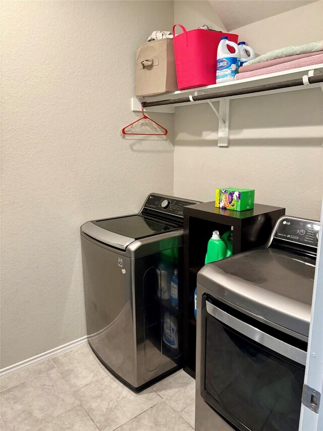 clothes washing area featuring laundry area, washer and dryer, and baseboards