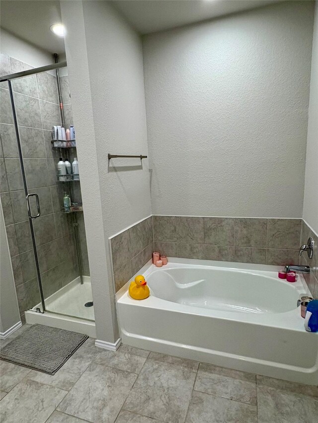 full bathroom featuring a bath and a shower stall