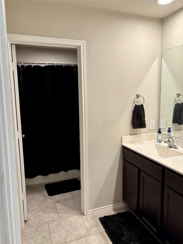 full bathroom featuring tile patterned flooring, baseboards, vanity, and a shower with curtain