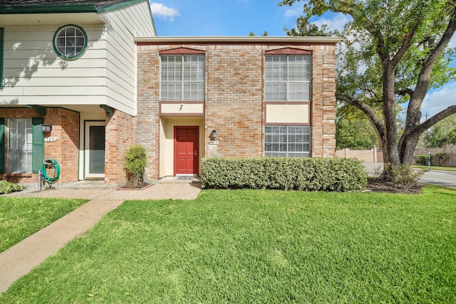 view of front of house featuring a front yard and brick siding