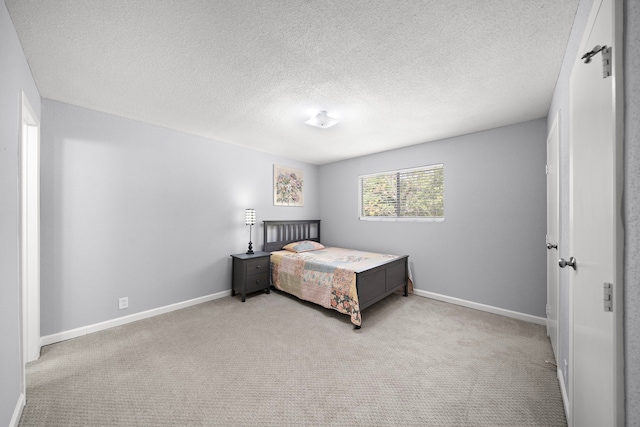 carpeted bedroom with baseboards and a textured ceiling