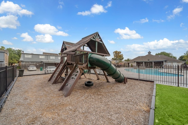 community playground with fence and a fenced in pool