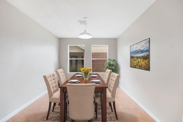 dining space featuring light tile patterned floors, visible vents, and baseboards