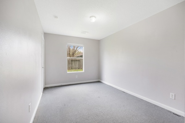 unfurnished room with baseboards and carpet