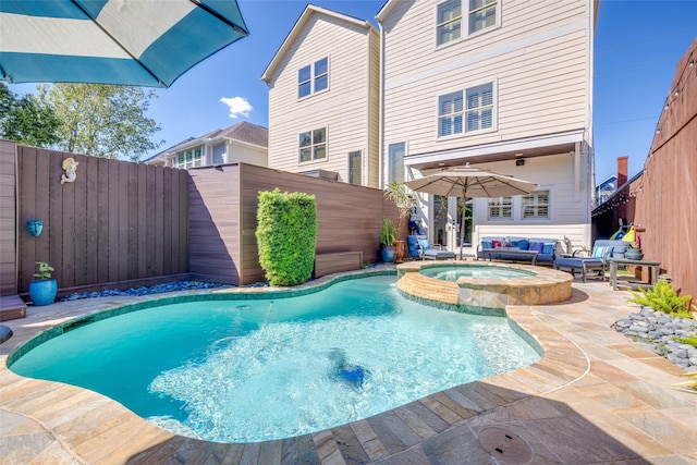 view of pool featuring a pool with connected hot tub, a fenced backyard, and a patio