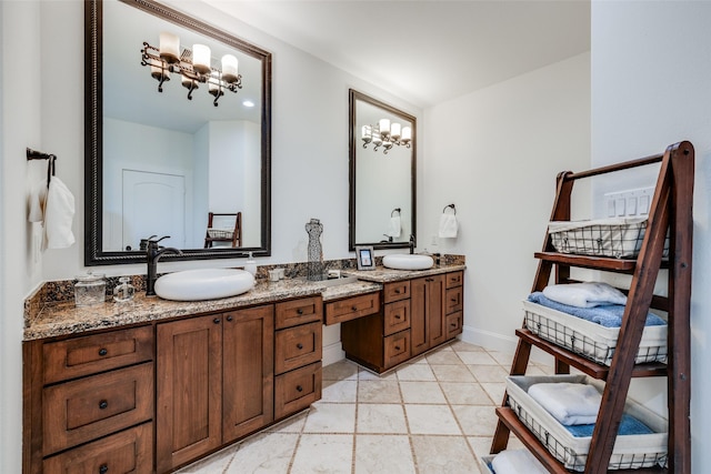 full bath featuring double vanity, a sink, and baseboards