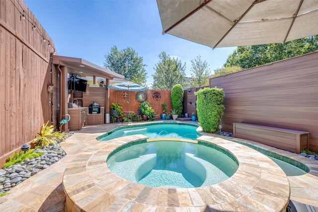 view of swimming pool featuring a patio area, a fenced backyard, and a pool with connected hot tub