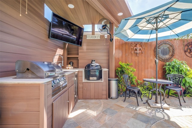 view of patio / terrace with area for grilling, an outdoor kitchen, and fence