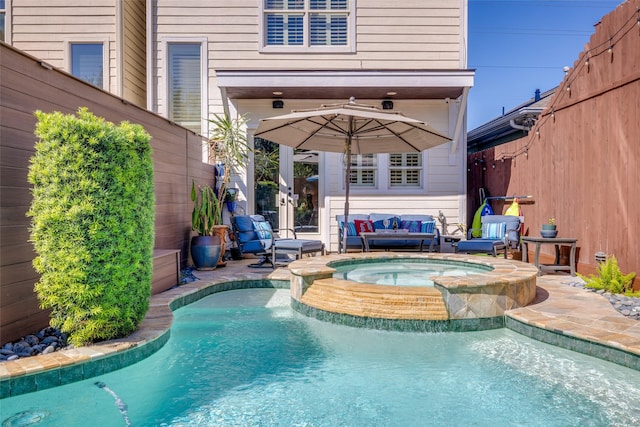 view of pool featuring a pool with connected hot tub and fence