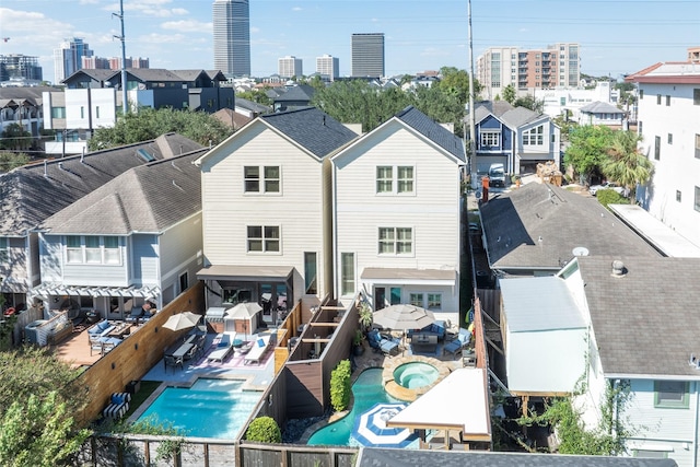 rear view of house with a patio, a fenced backyard, and a hot tub