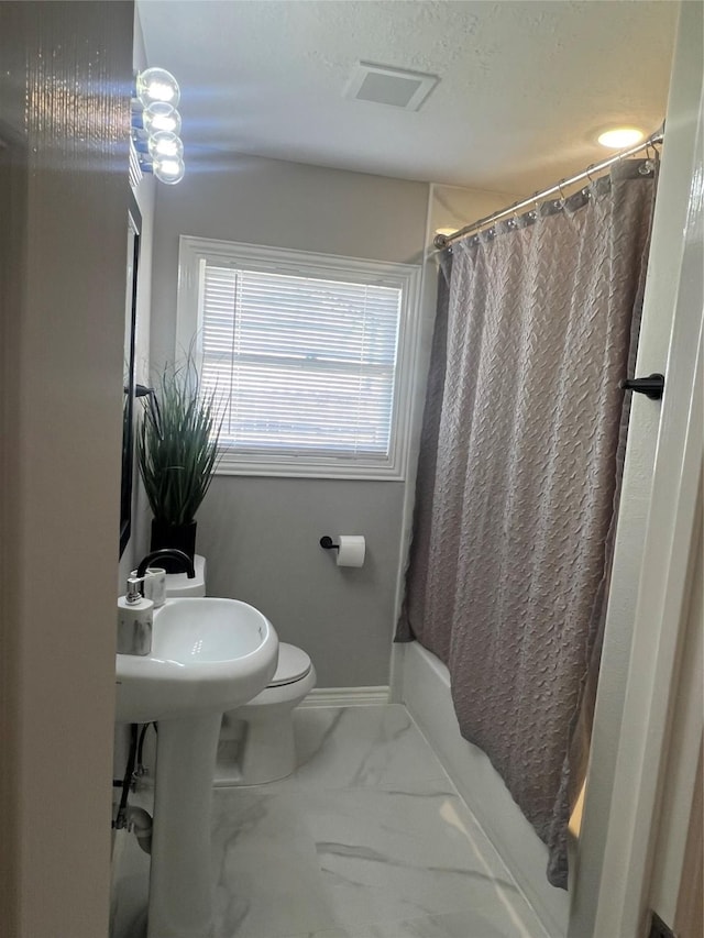 bathroom featuring curtained shower, toilet, visible vents, baseboards, and marble finish floor