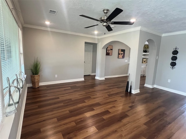 unfurnished living room with arched walkways, dark wood-style flooring, and visible vents