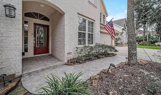 view of exterior entry featuring brick siding