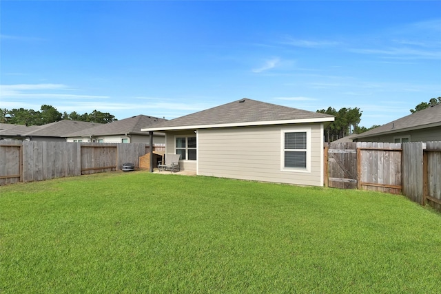 rear view of property featuring a fenced backyard and a yard