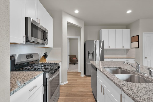 kitchen with appliances with stainless steel finishes, a sink, and white cabinets